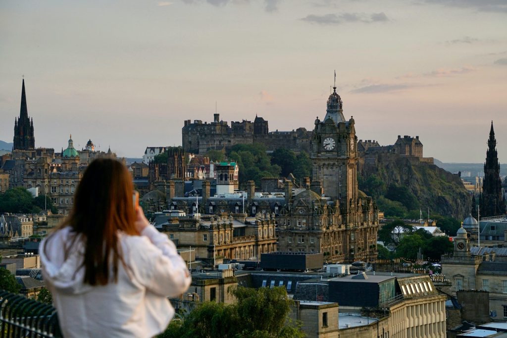 Woman taking a photo of Edinburgh castle